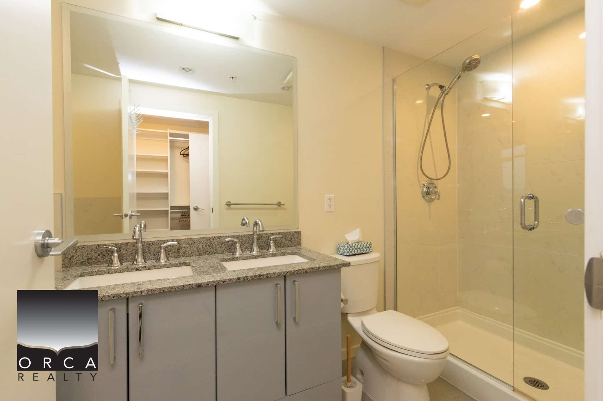 14 (3) Modern bathroom with double sinks, granite countertop, and walk-in shower in a contemporary condo - ideal for Vancouver real estate buyers.