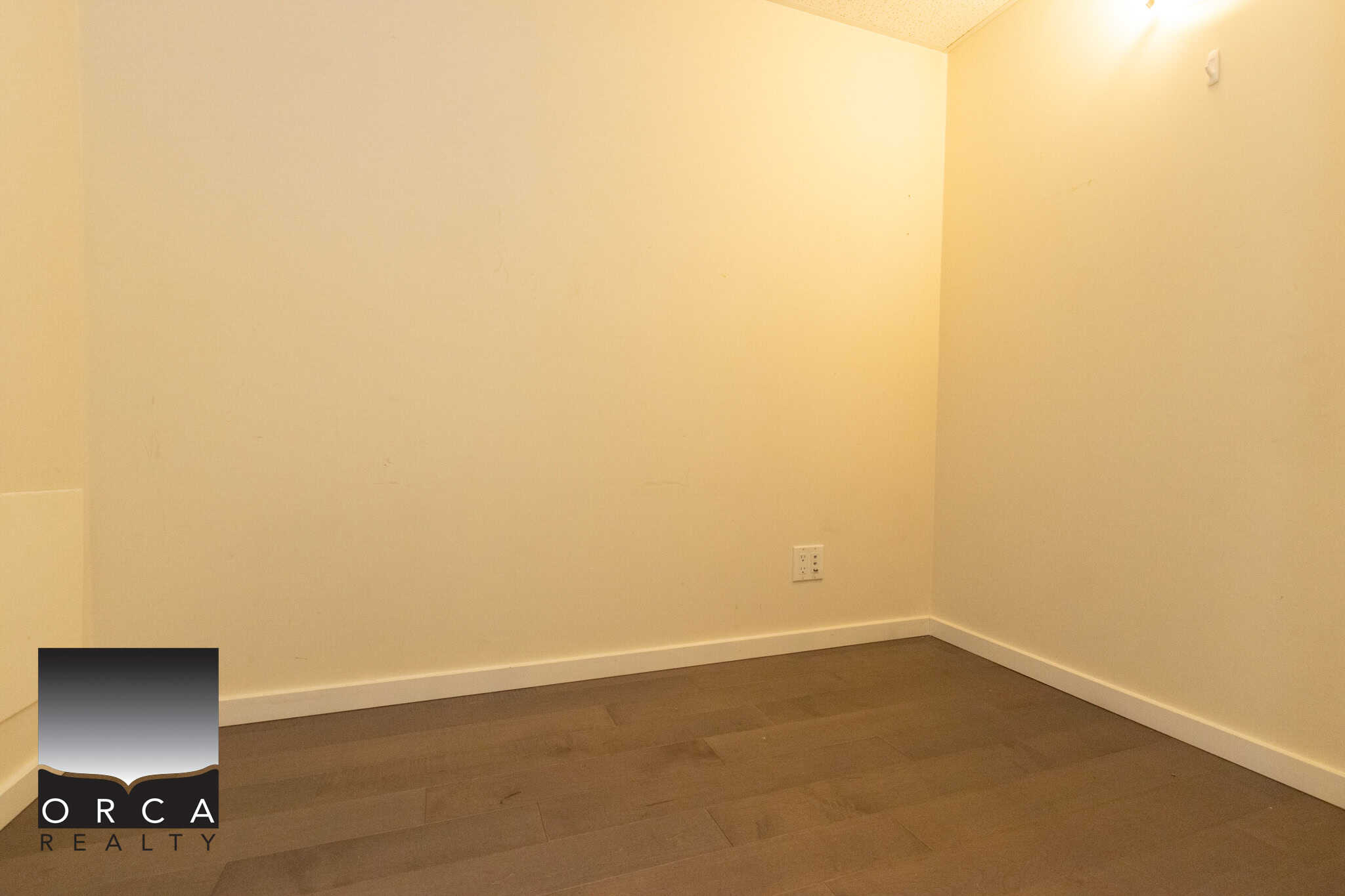 16 (5) Bright empty room with beige walls and hardwood flooring, ideal for real estate listings, rentals, or investments in the Vancouver Island region.