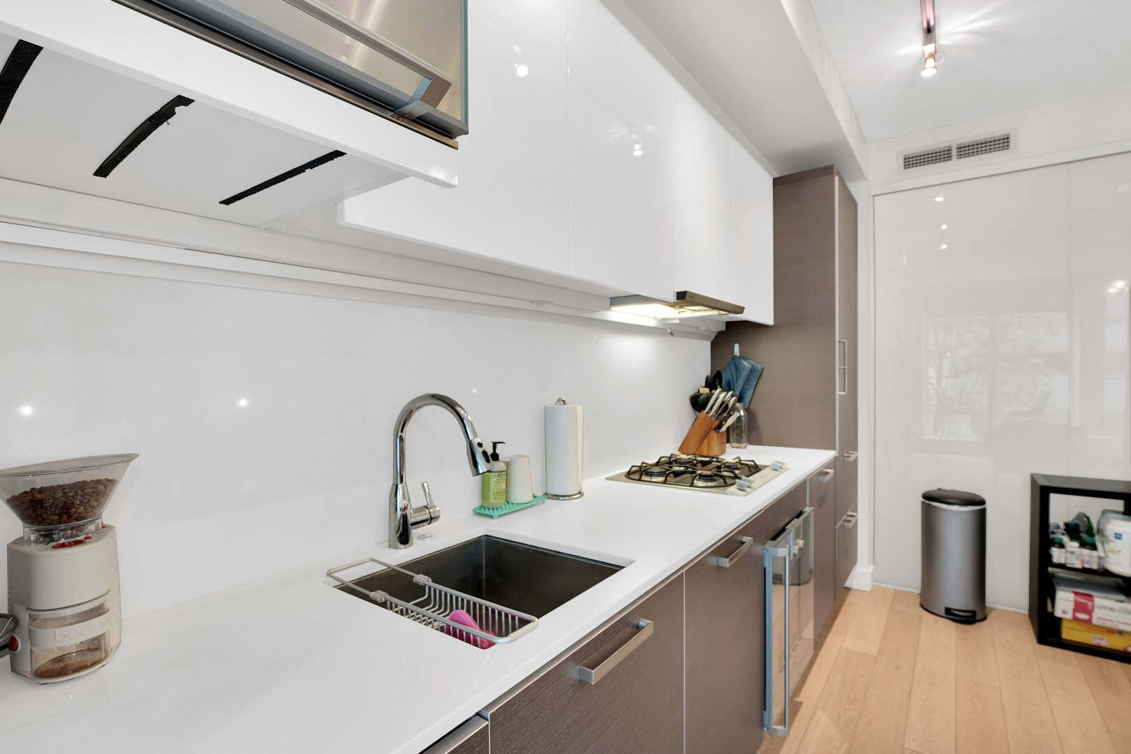 19 Bright modern kitchen with white countertops, stainless steel appliances, and contemporary cabinetry, ideal for Vancouver Island real estate buyers seeking stylish homes.