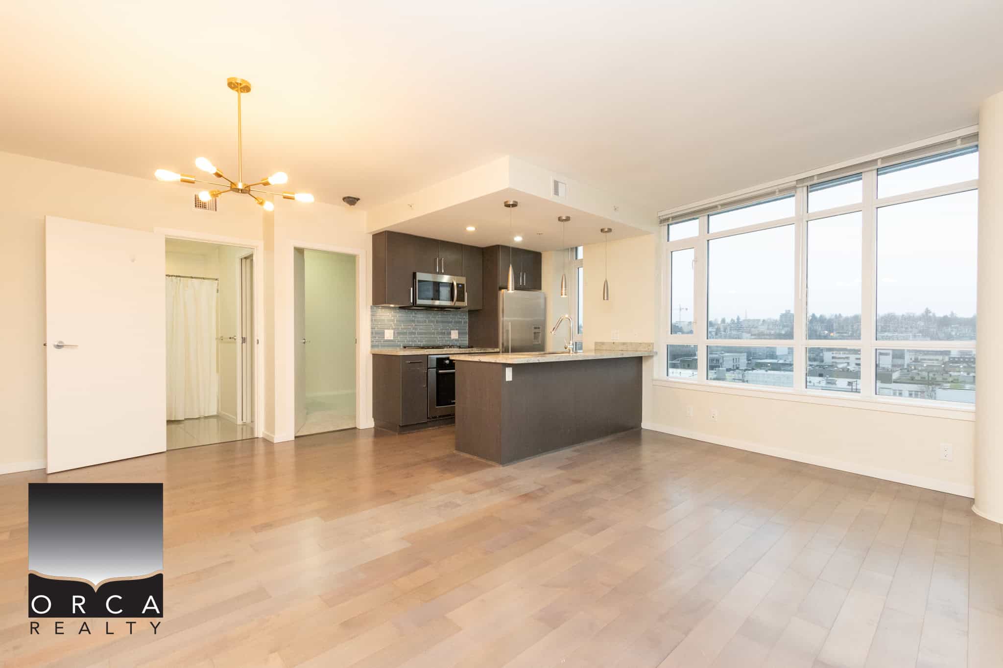 3 (5) Modern open-concept kitchen and living area in a high-rise condo with panoramic city views, hardwood flooring, and contemporary finishes, ideal for Vancouver real estate buyers.