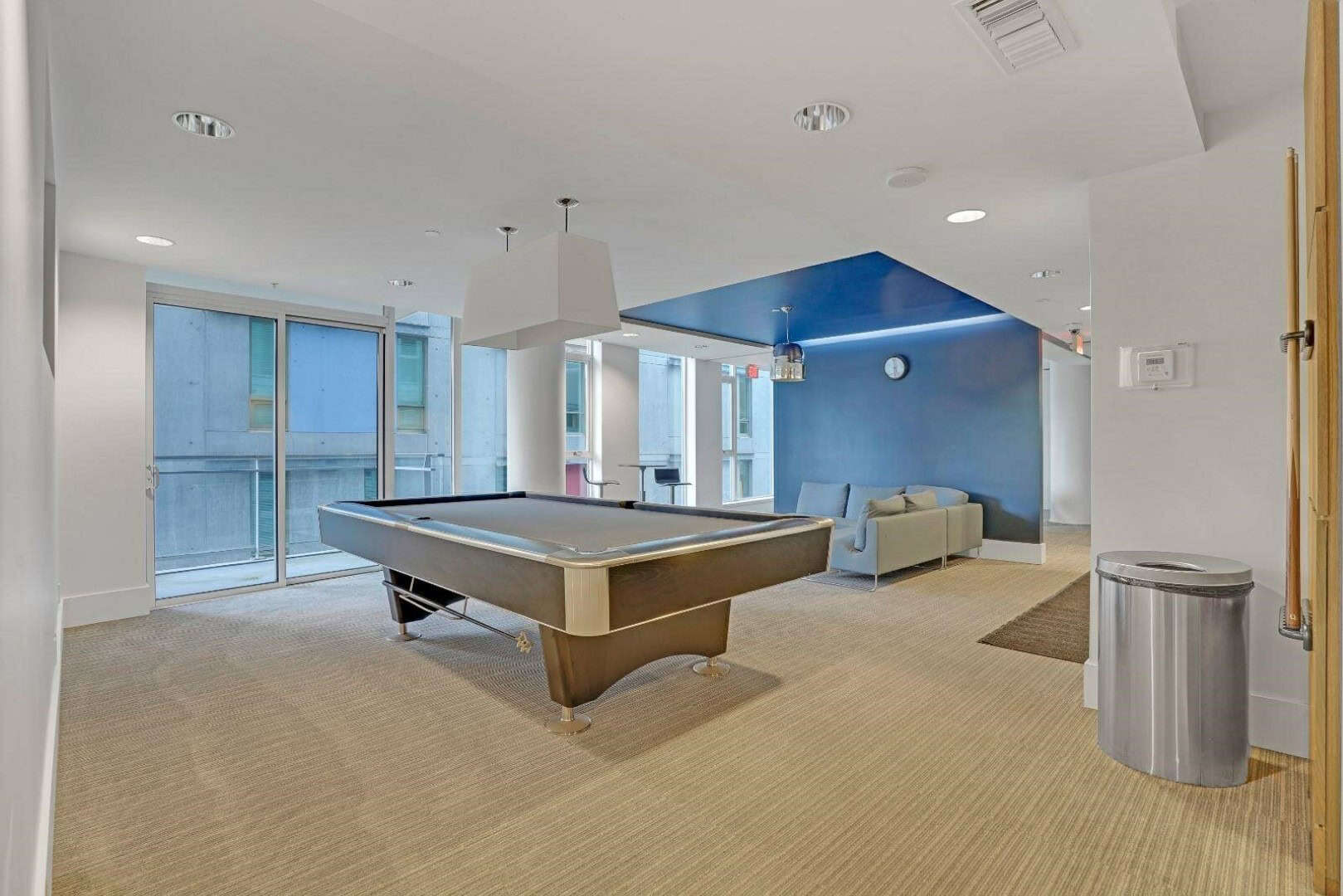 30 Contemporary indoor recreation area with pool table, lounge seating, large windows, and modern decor, ideal for relaxation and socializing at Orca Realty Inc.