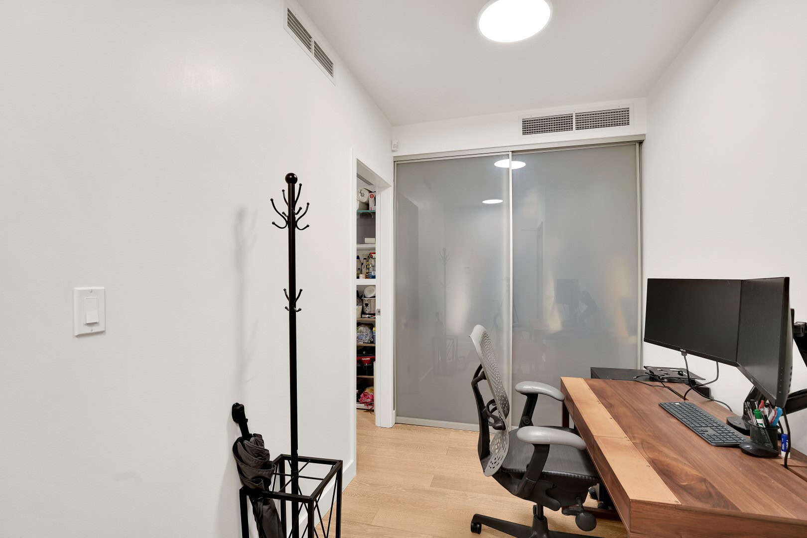 5 Versatile home office with dual monitors, modern ergonomic chair, natural light, and storage space, ideal for remote work and professional setups in Vancouver's real estate market.