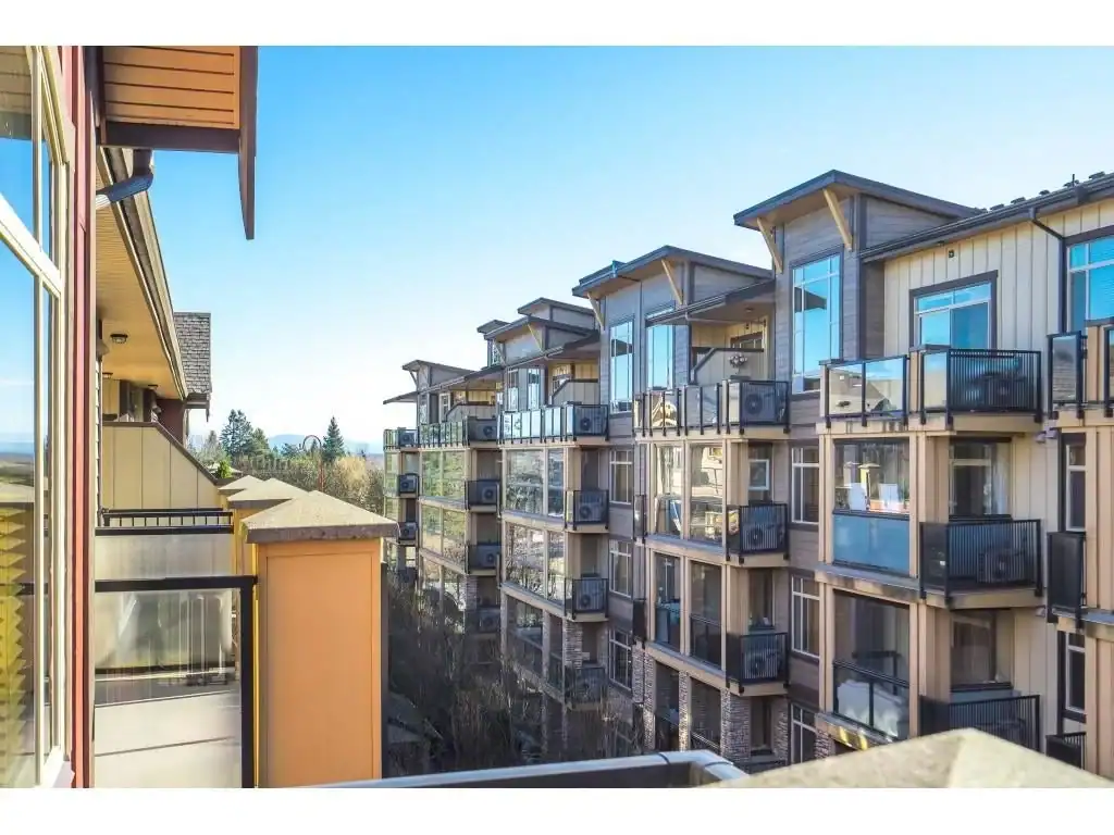 Modern apartment balconies with glass railings in a contemporary residential building in a scenic suburban neighbourhood.