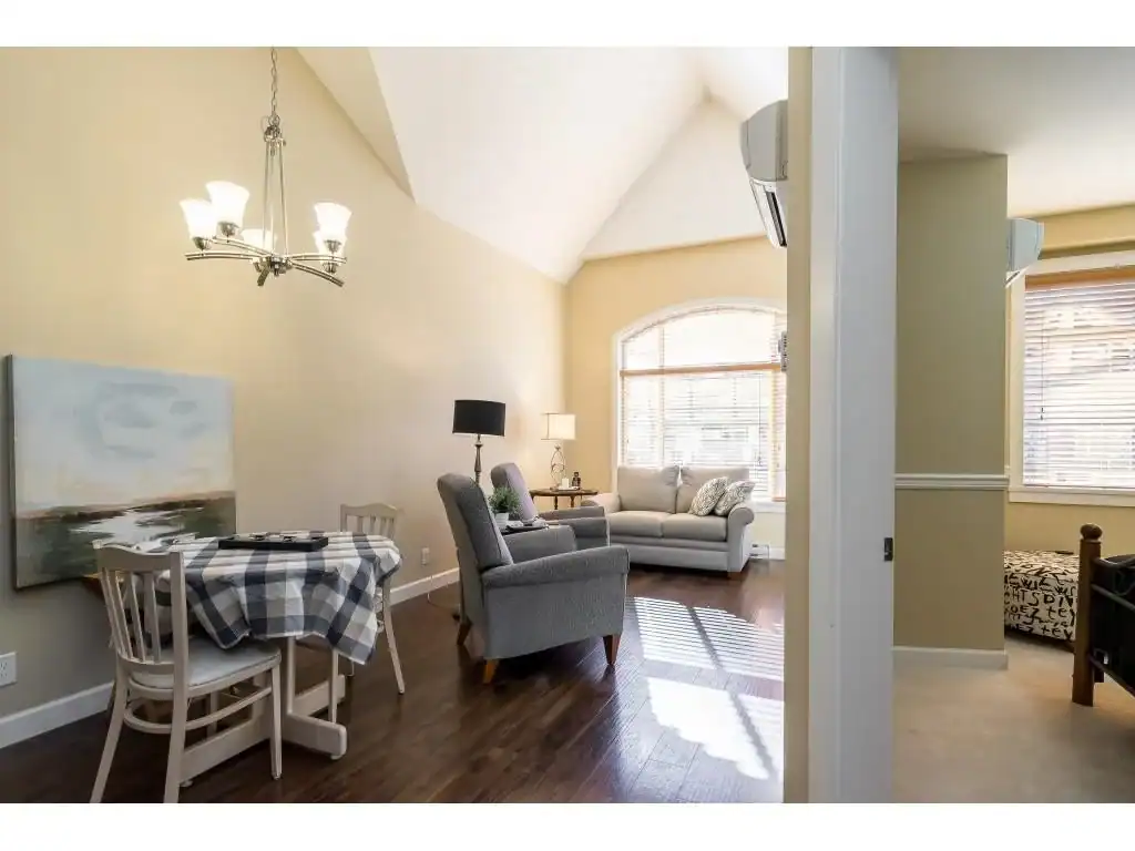 Bright and welcoming living room with large windows, modern furnishings, and hardwood flooring, perfect for family living and entertaining in Vancouver real estate.