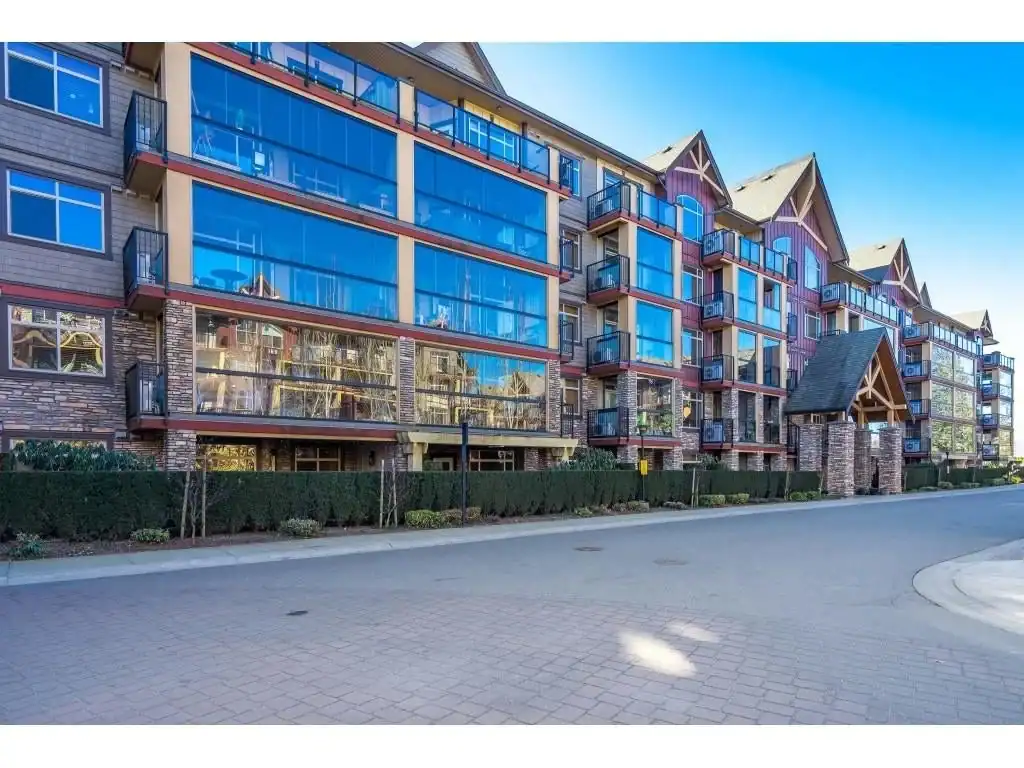 Modern multi-story residential building with large glass windows and balconies in a scenic neighbourhood in BC.