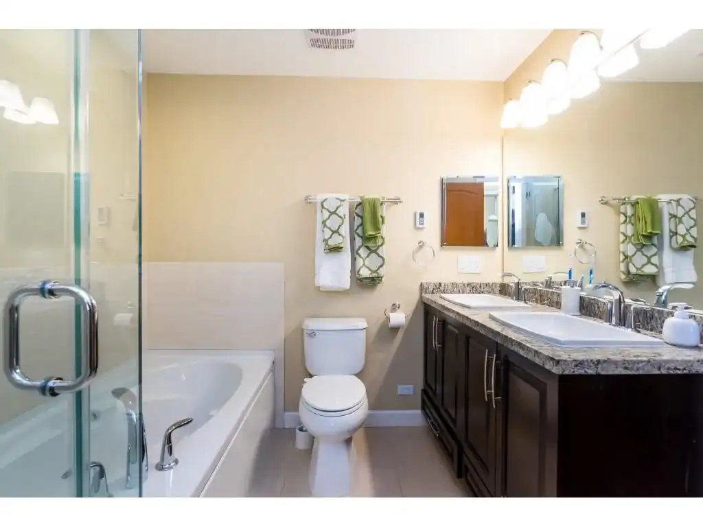 Modern bathroom with dual sinks, granite countertop, walk-in shower, and relaxing bathtub featuring contemporary decor, bright lighting, and functional accessories, ideal for healthy living and home comfort.