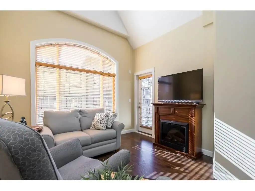 Bright living room in Vancouver with large window, cozy sofas, and modern fireplace, showcasing serene interior with natural light, perfect for real estate listings and property tour advertising.