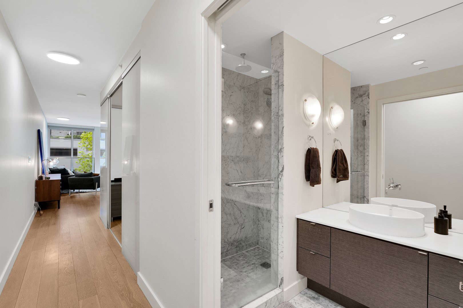 6 Modern bathroom with marble shower and double vanity, open-concept living space, contemporary interior design, natural light, and minimalist decor, representing luxury real estate by Orca Realty Inc.