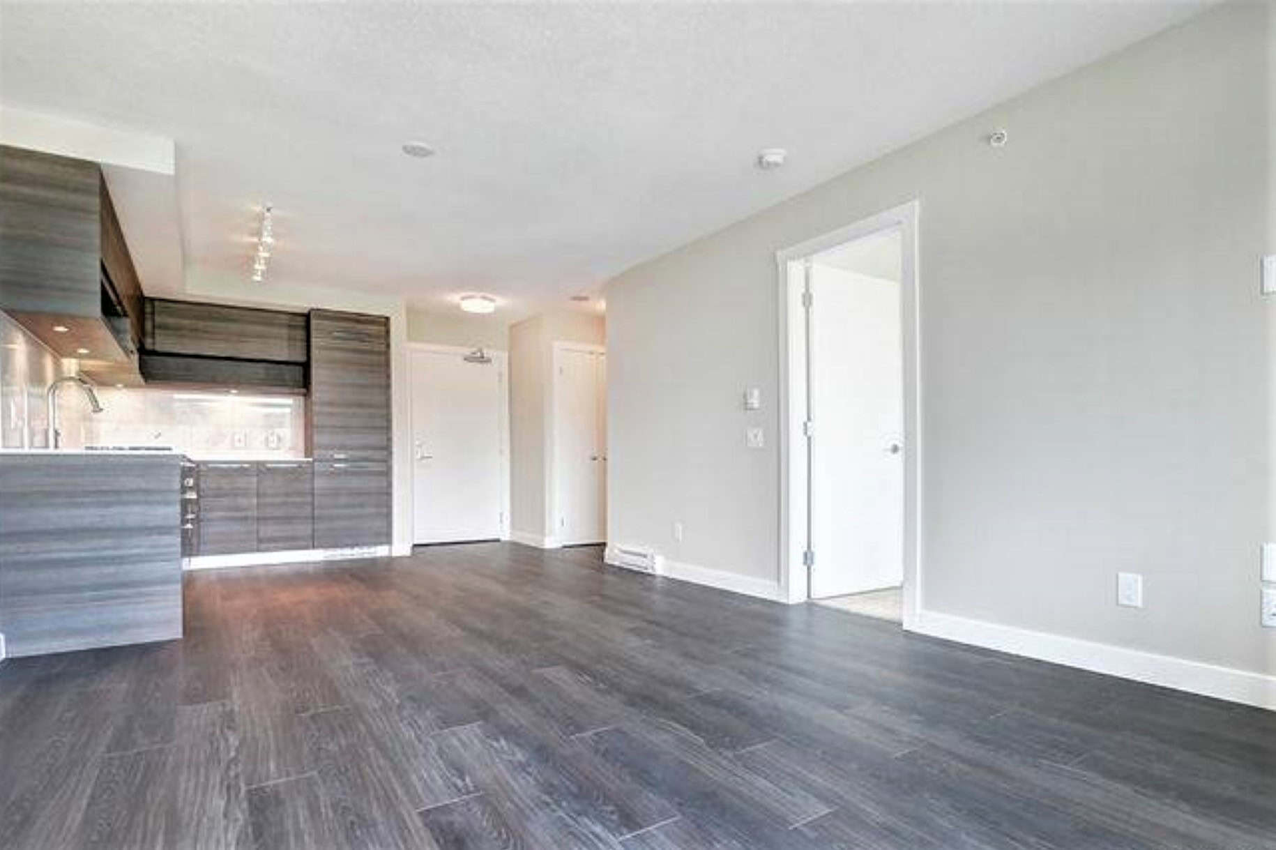 Bright modern apartment interior with open-concept living space, stylish wooden flooring, and updated kitchen – ideal for Vancouver real estate buyers seeking contemporary condos.