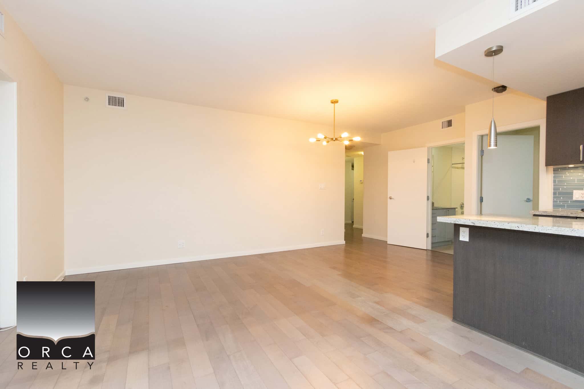 8 (2) Bright open-concept living room with modern kitchen, hardwood floors, and ample natural light, perfect for Calgary real estate buyers searching for contemporary condos or apartments.