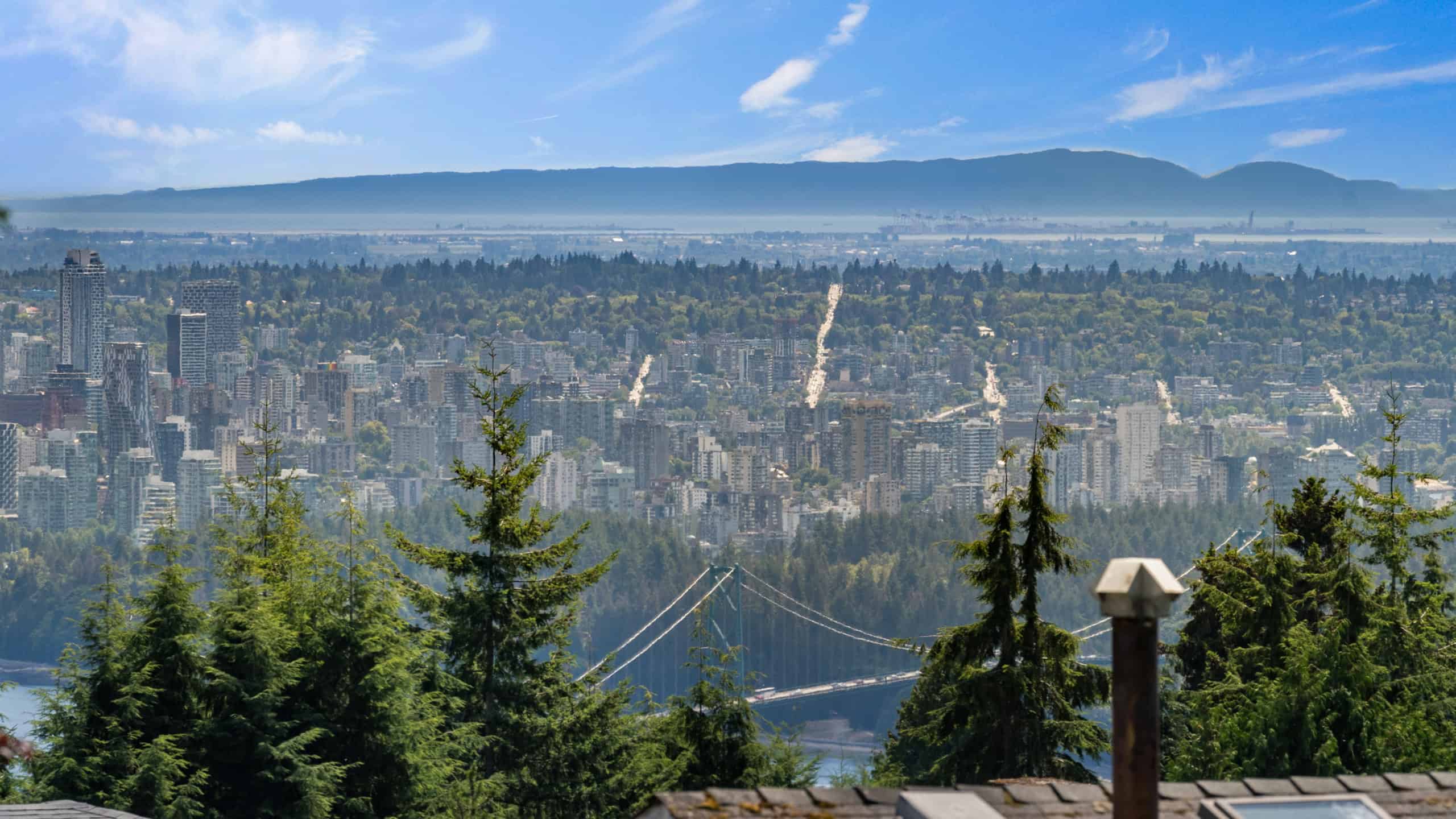 Ocean View from 865 Andover Crescent, West Vancouver Stunning panoramic view of West Vancouver and Vancouver skyline from 865 Andover Crescent, showcasing lush greenery and mountain backdrop.
