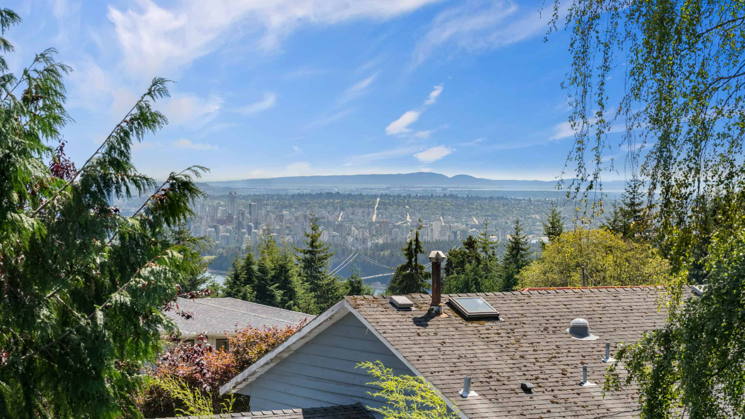 Elegant West Vancouver Home with Scenic Views Beautiful West Vancouver home overlooking the city and ocean, surrounded by lush greenery and mature trees, offering a peaceful and luxurious living environment.