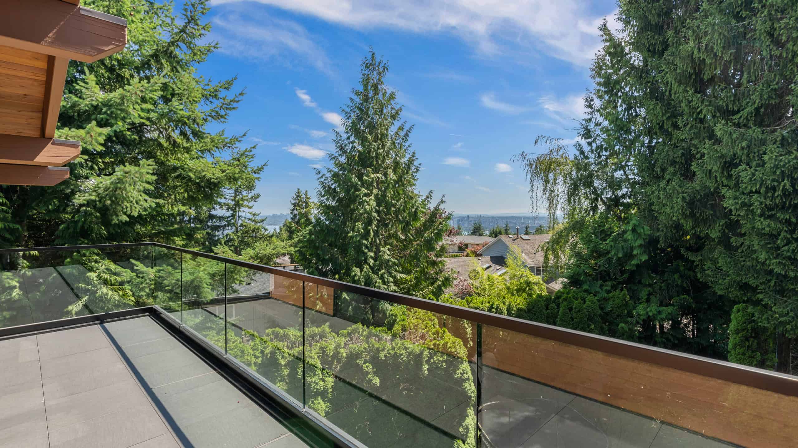 Modern West Vancouver Home with Scenic Views Beautiful view from a West Vancouver home featuring lush greenery and a clear blue sky, perfect for outdoor living and enjoying nature.