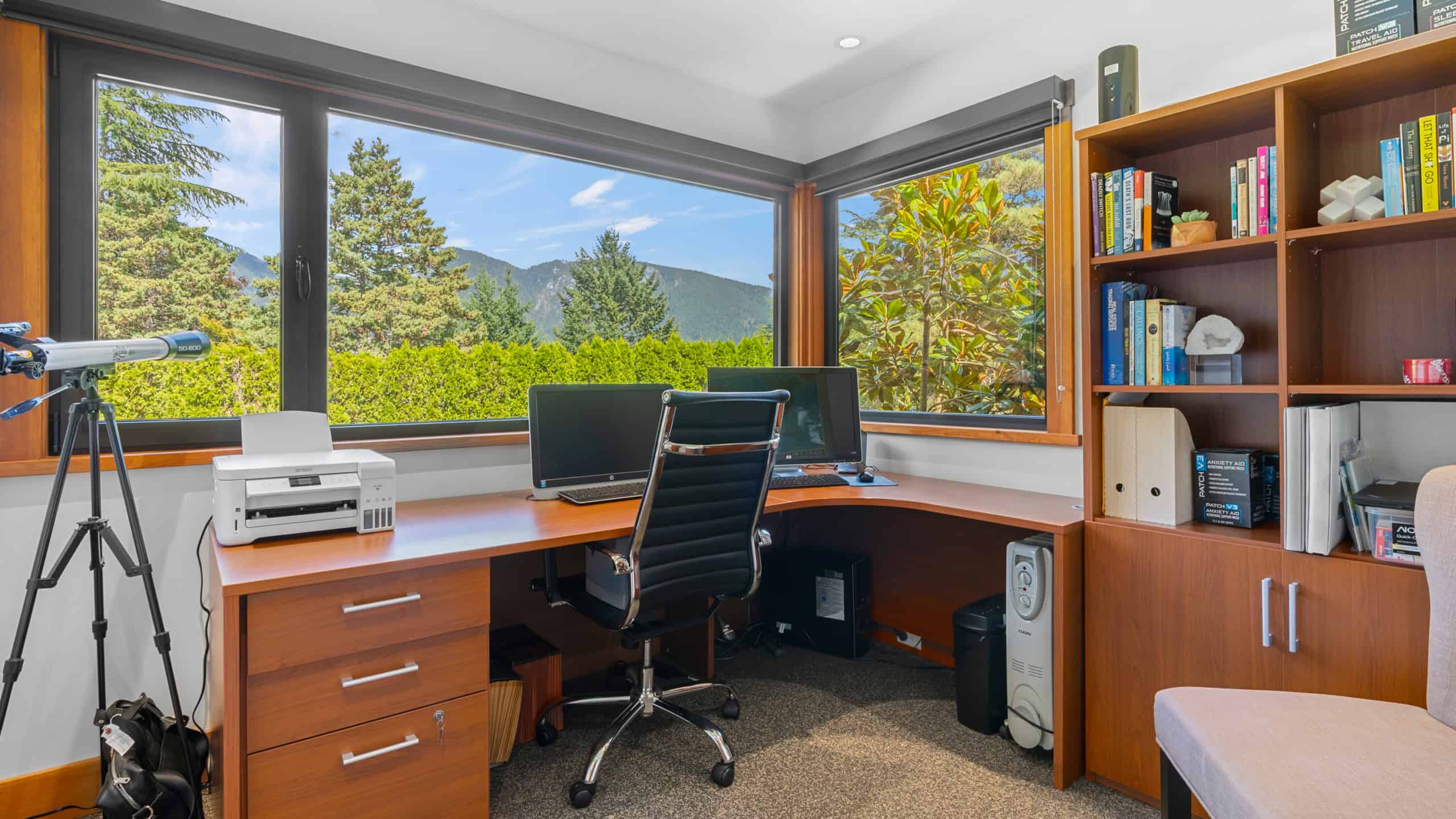 Elegant home office with mountain views in West Vancouver Bright home office featuring large windows with scenic mountain and greenery views in West Vancouver, ideal for remote work or study.