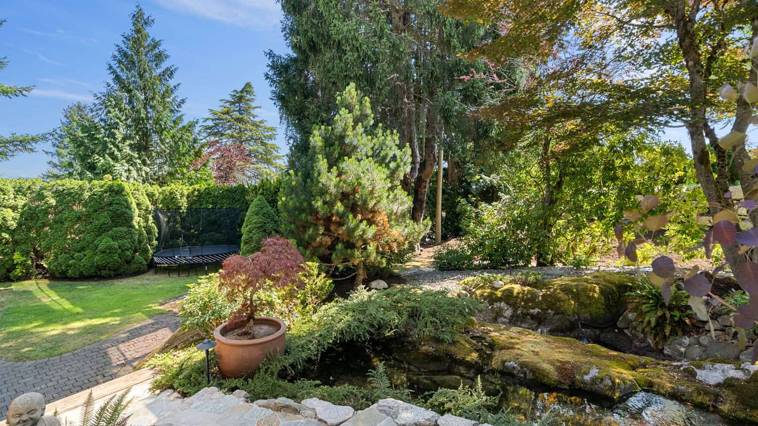 Elegant West Vancouver Garden Scene Beautiful landscaped garden with lush greenery and a small pond at 865 Andover Crescent, West Vancouver. Perfect for outdoor living and enjoying nature.