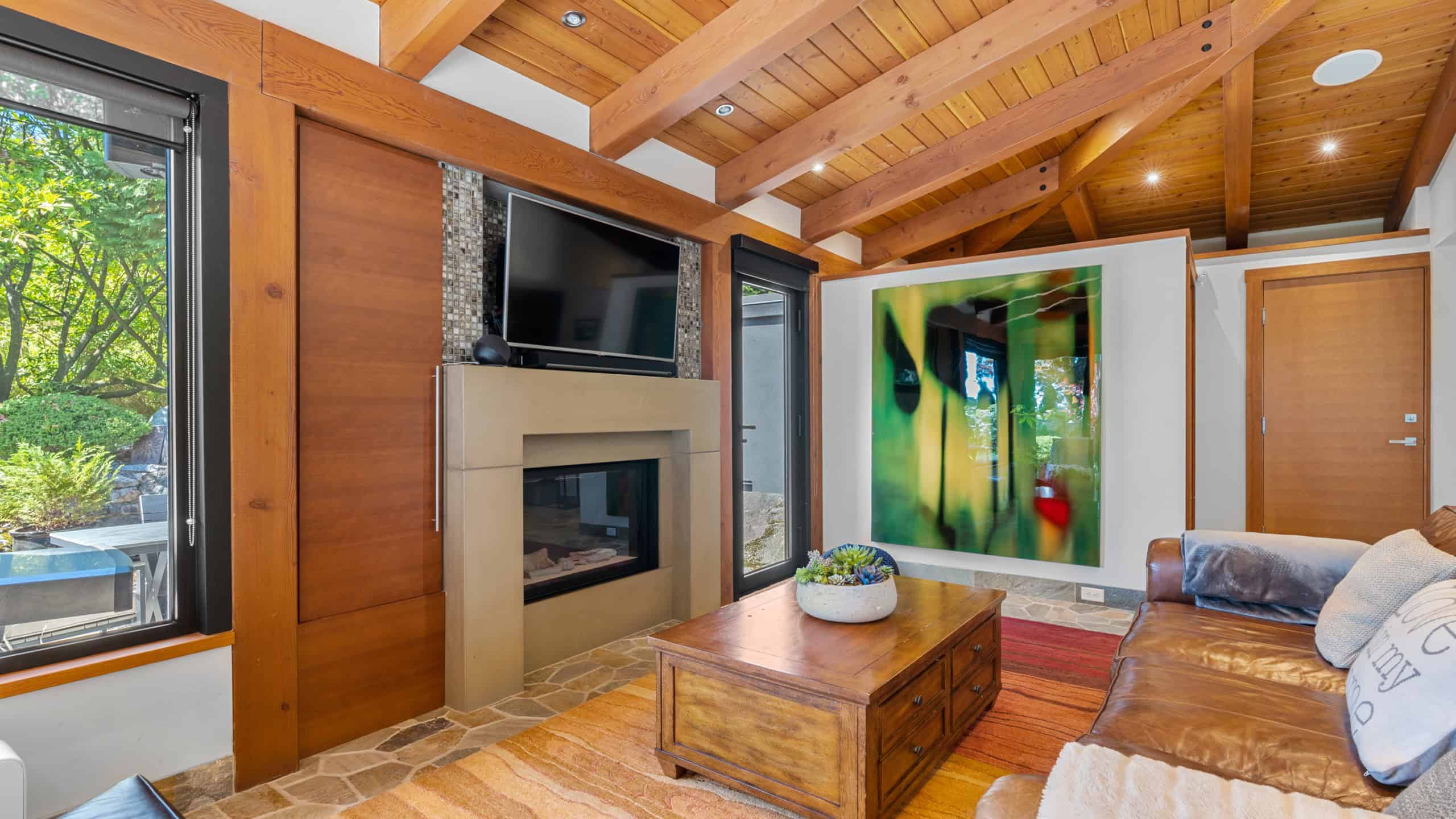 Elegant West Vancouver living room with modern fireplace and large windows Spacious West Vancouver living room featuring a contemporary fireplace, natural wood accents, and expansive windows that bring in abundant natural light. Perfect for relaxing or entertaining.