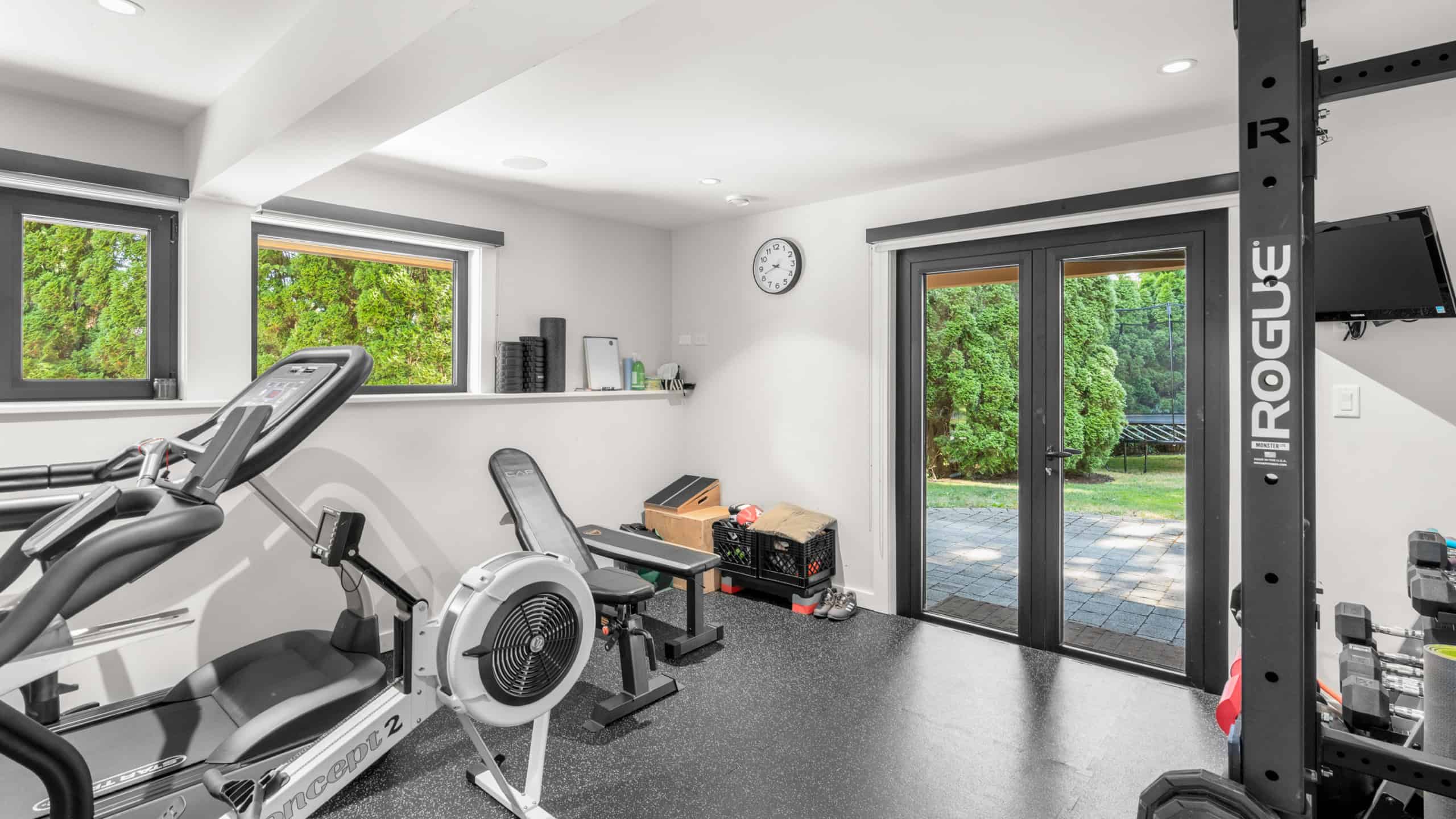 Modern Home Gym at 865 Andover Crescent, West Vancouver Indoor home gym with fitness equipment and large windows overlooking lush greenery.