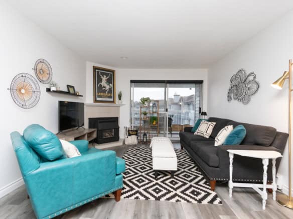Bright living room with modern furnishings, fireplace, and sliding glass doors leading to balcony – ideal for Vancouver-style condos and real estate in BC.
