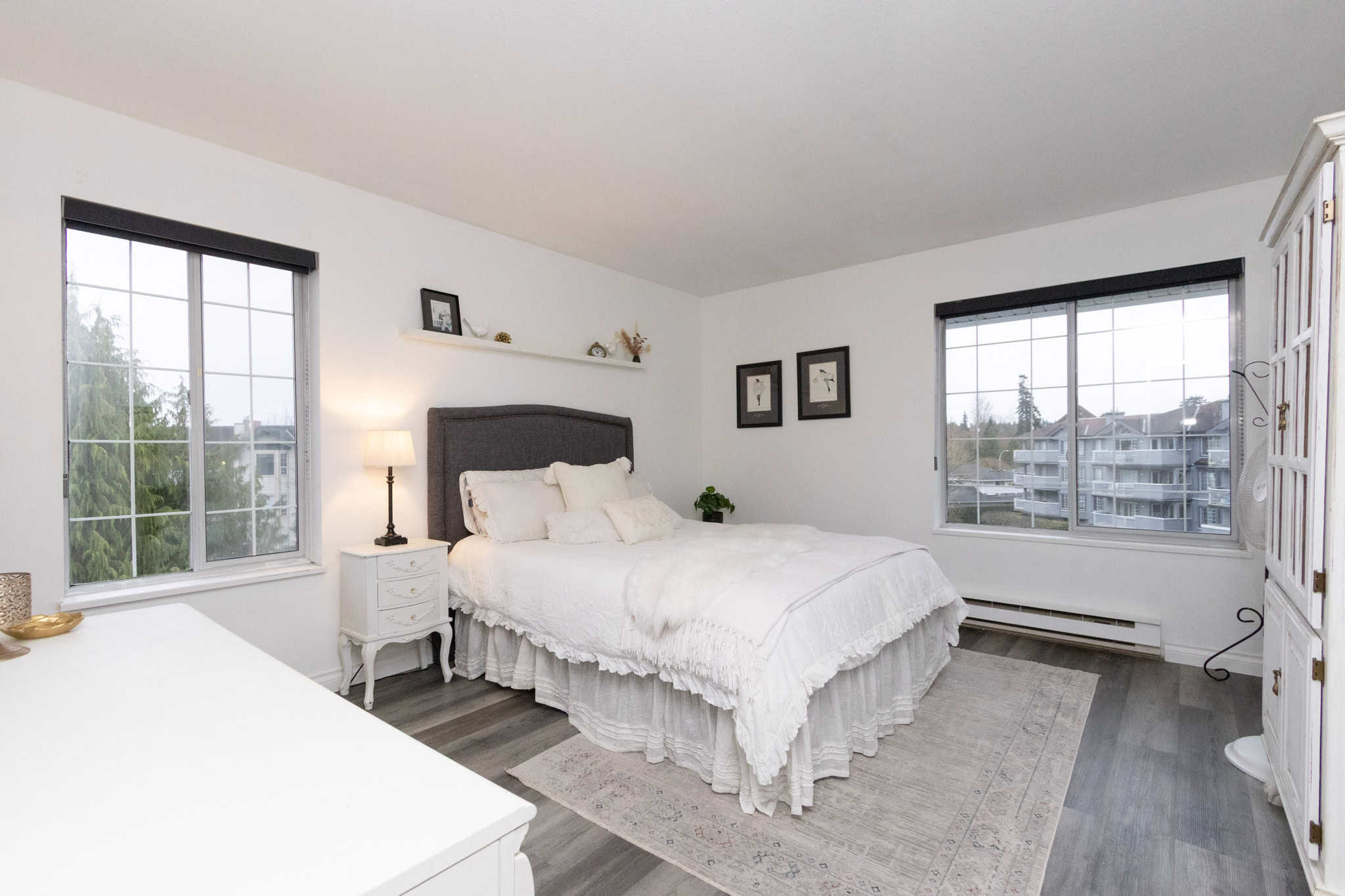 Bright and spacious bedroom in a Vancouver property listed by Orca Realty Inc., featuring large windows, elegant decor, and modern furnishings, perfect for homebuyers seeking comfort and style.