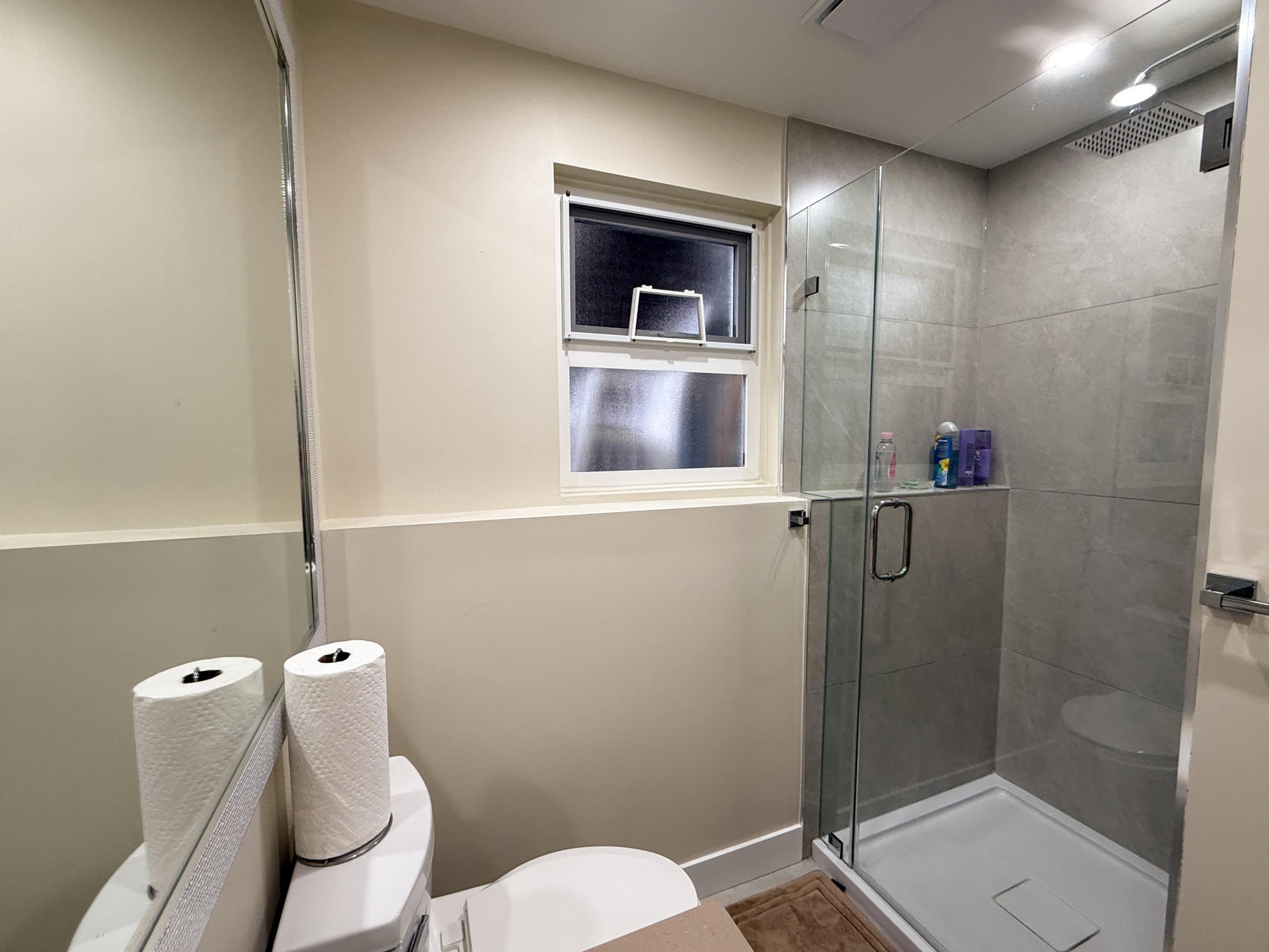 Bathroom with walk-in shower, glass door, and minimalist design in North Vancouver home.