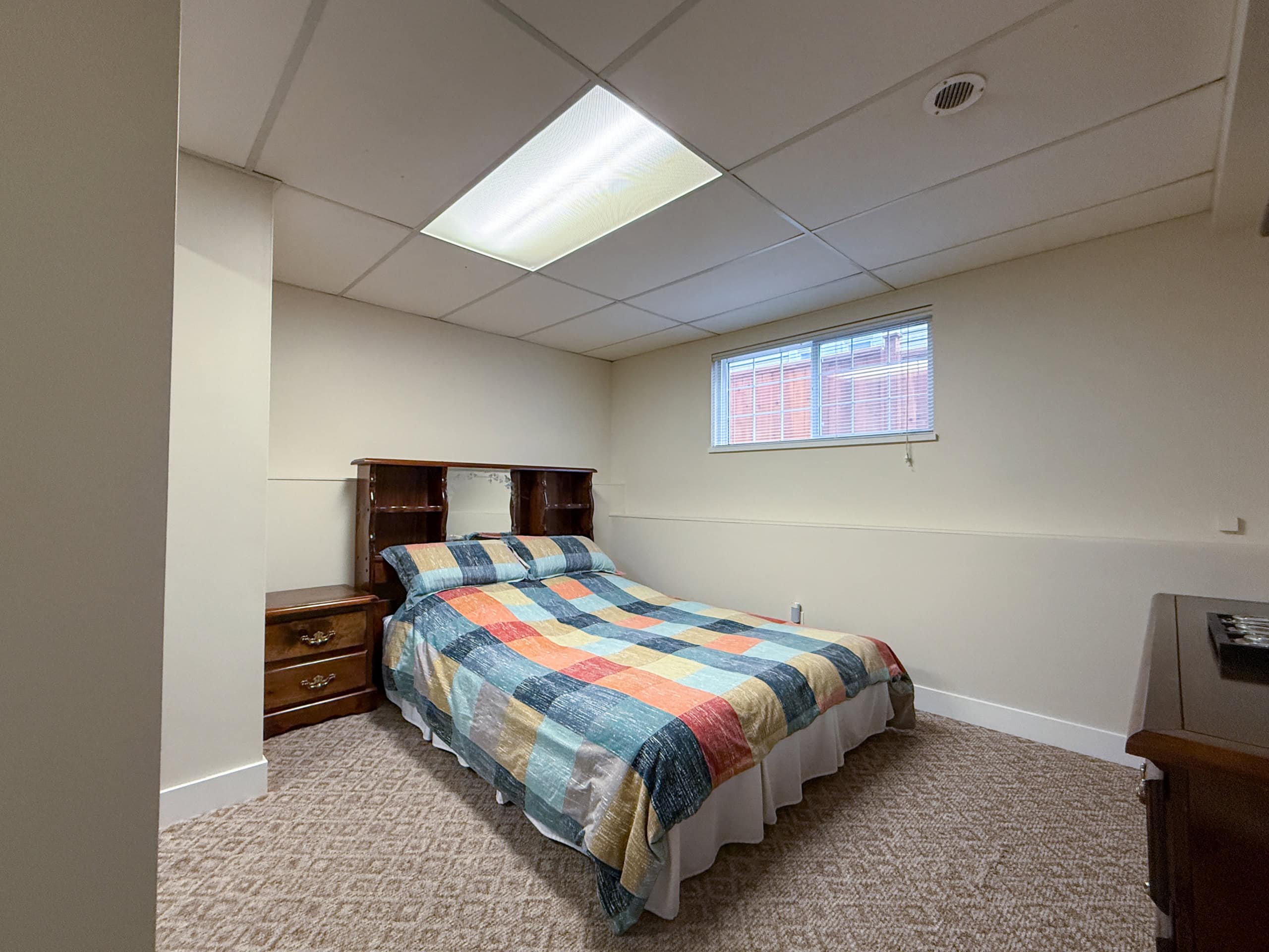 Bright bedroom with a cozy bed and natural light from window.