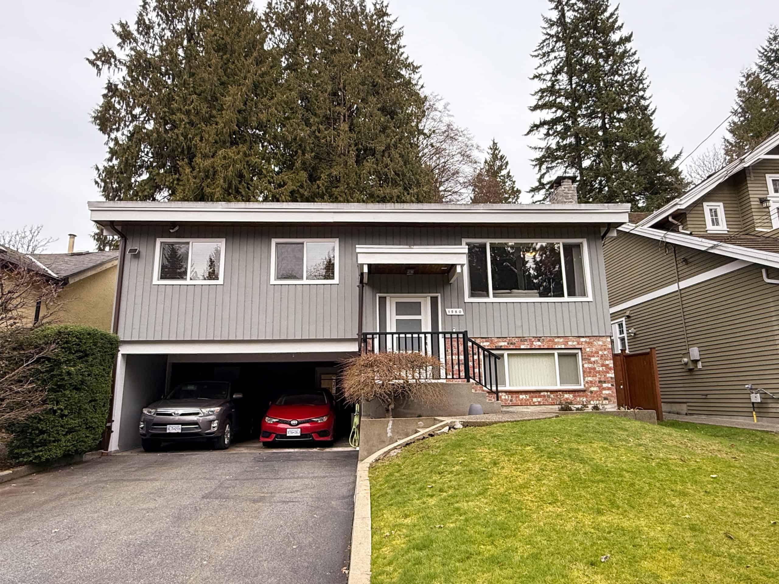 Beautiful contemporary house located at 1580 Dempsey Rd, North Vancouver, featuring a spacious garage, well-maintained lawn, and large windows offering natural light.
