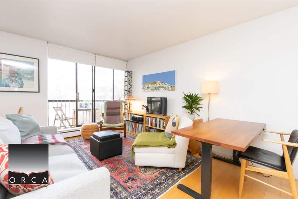 Bright living room with balcony access, modern decor, and cozy seating, ideal for Vancouver Island real estate. Featuring stylish furniture, artwork, and natural light, perfect for enjoying island living.