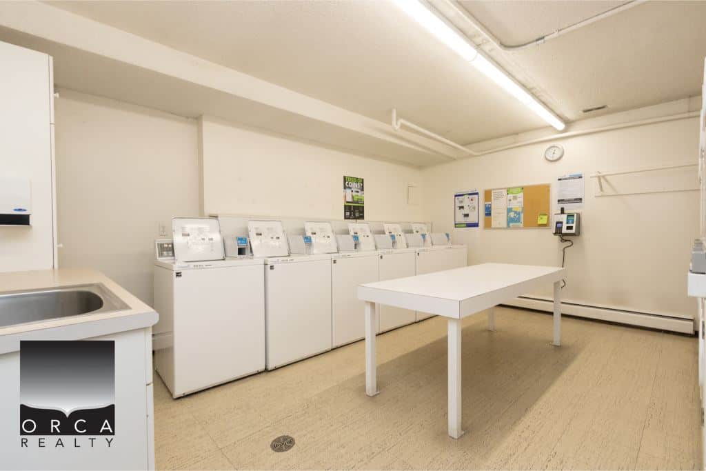 Laundry room with washing machines and utility area, featuring clean and organized space for tenants and residents. Suitable for property management and real estate needs in Vancouver.