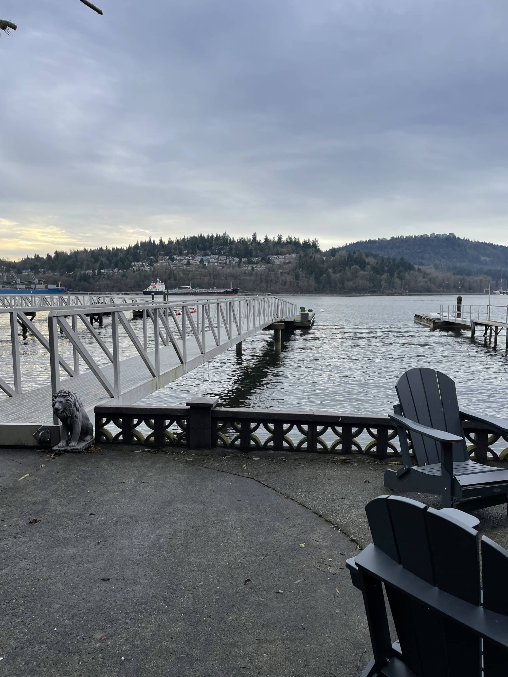 Tranquil waterfront scene at Orca Realty Inc., showcasing a scenic dock over calm waters with scenic hills in the background, ideal for coastal living and real estate investment in BC.