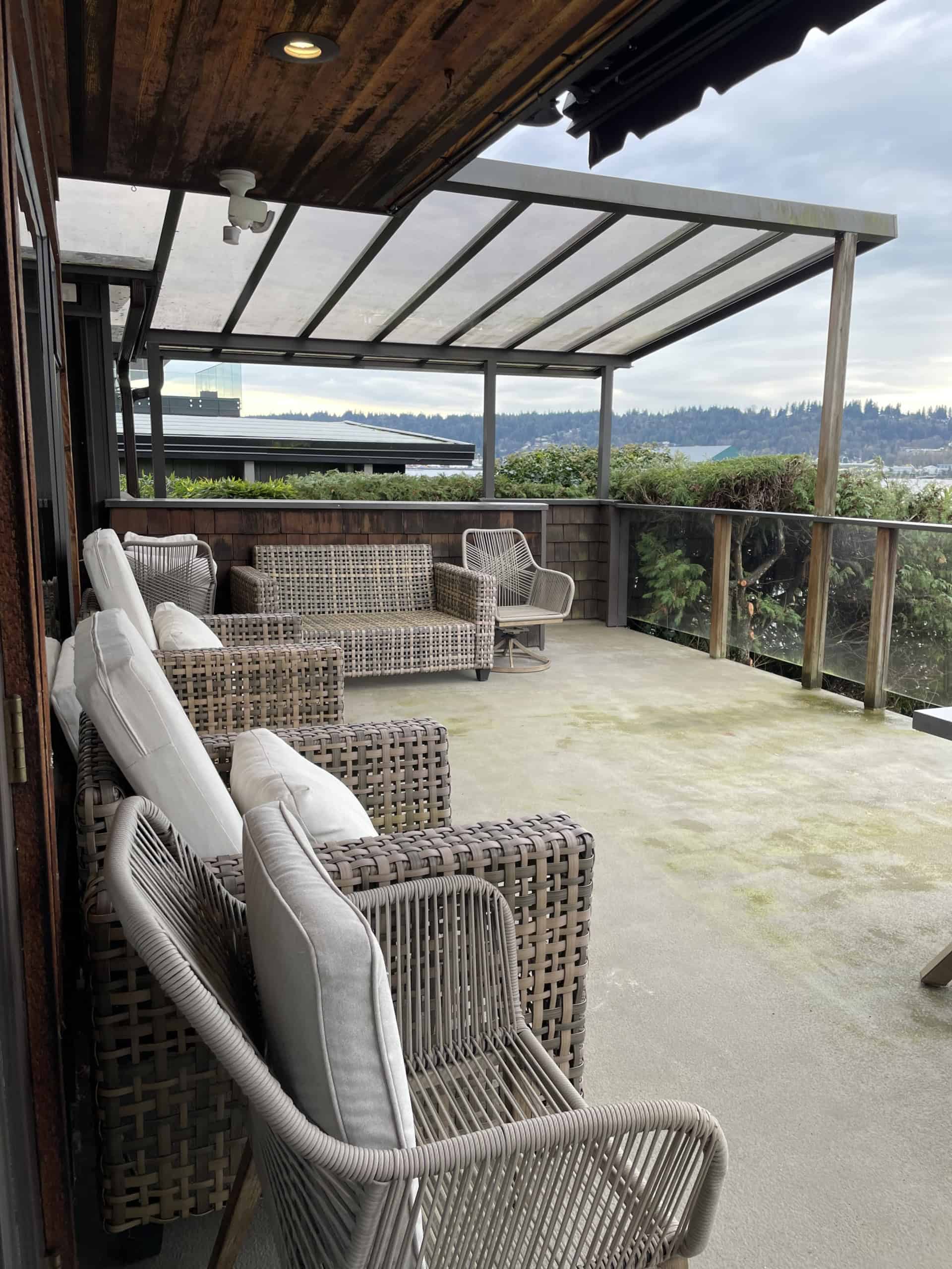 Outdoor balcony with wicker and cushioned seating, overlooking scenic views, perfect for relaxing or entertaining in Vancouver.