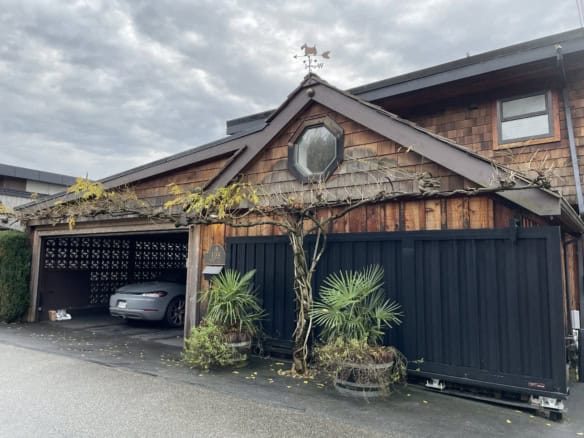 Bright, modern home with a unique wooden exterior, lush greenery, and a covered parking area in a desirable neighbourhood, ideal for Vancouver Island real estate buyers seeking comfort and style.
