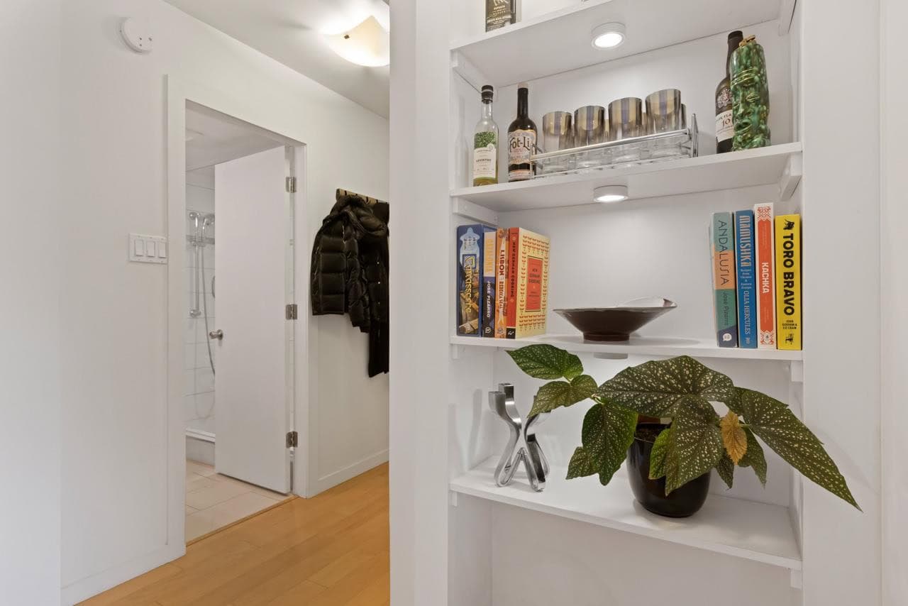 Bright interior image of a modern home with a stylish white shelving unit, cozy decor, and a glimpse of the bathroom, showcasing Vancouver real estate, home staging, and property features by Orca Realty Inc.