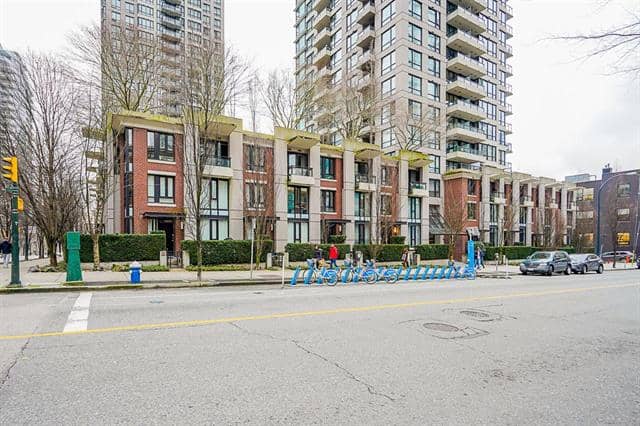 Modern Vancouver apartment building with bike racks and street view.