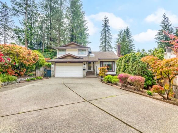 Spacious North Vancouver property featuring a well-maintained house with a basement suite, surrounded by lush landscaping and mature trees, ideal for families or investors.