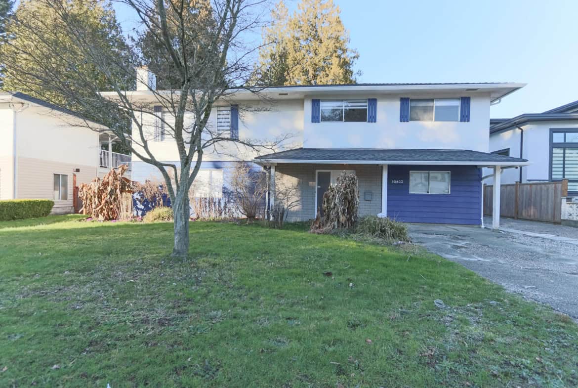 Exterior view of a two-story house in Delta with a spacious front yard, mature trees, and a driveway, showcasing a family-friendly residential property.
