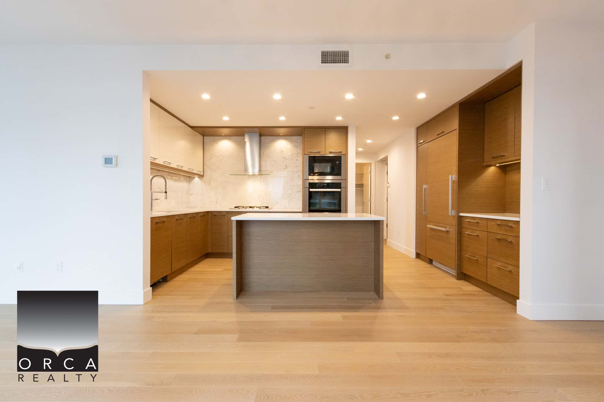 Spacious kitchen featuring contemporary wooden cabinetry, stainless steel appliances, and a central island, perfect for family living and entertaining in Vancouver.