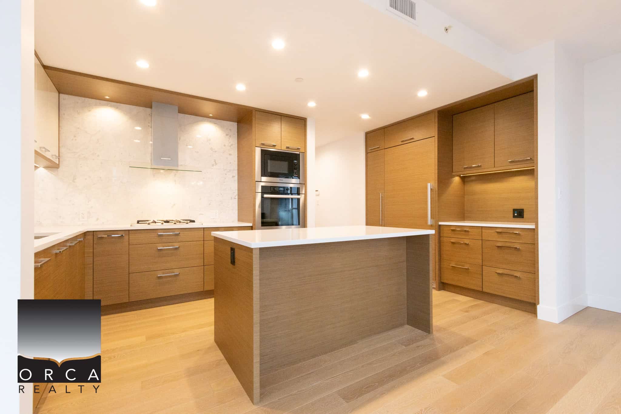 Beautiful contemporary kitchen featuring warm wood cabinets, a spacious island, and modern appliances in Vancouver.