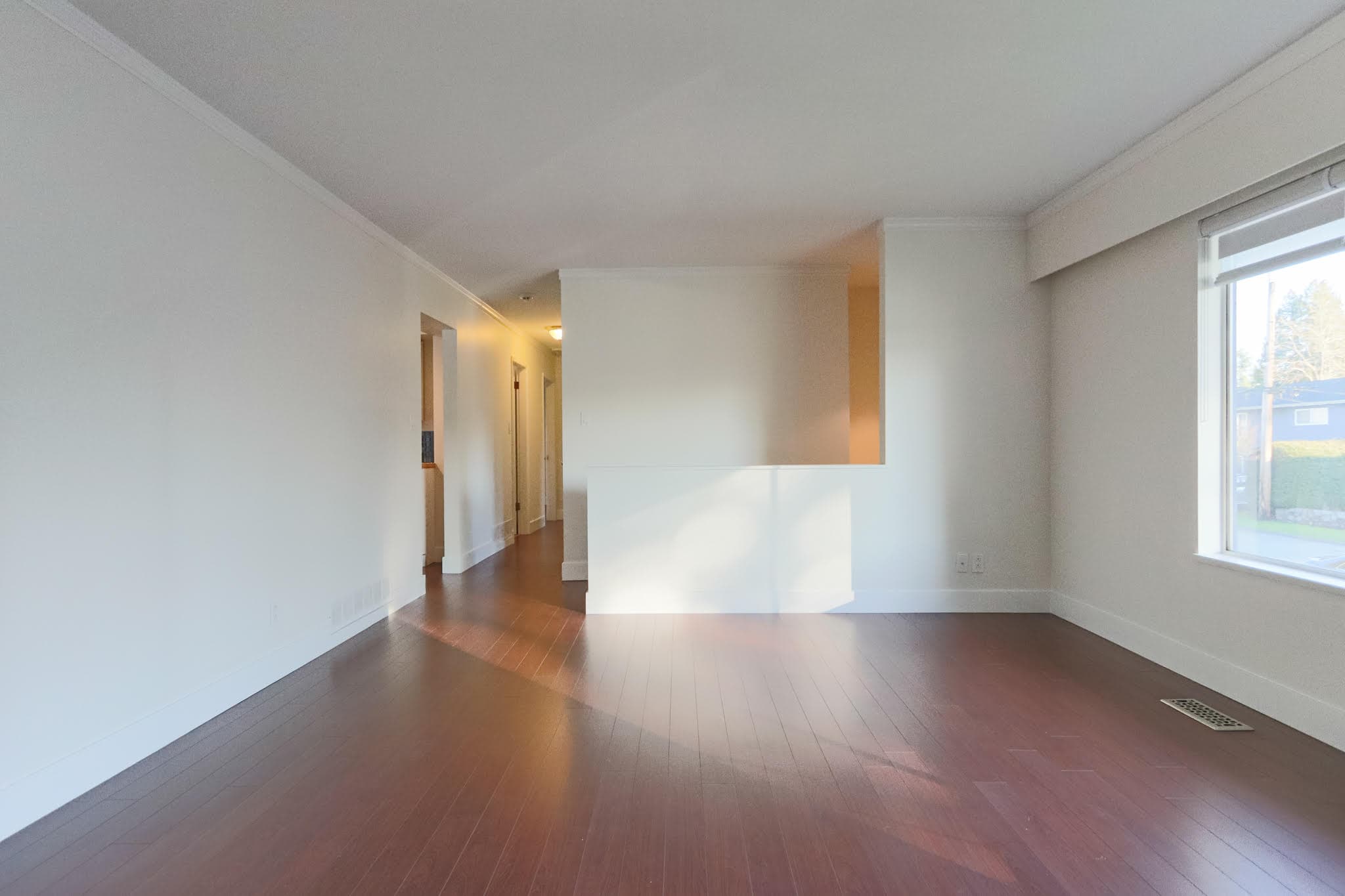 Upstairs living room with large window and hardwood floors in Delta property.