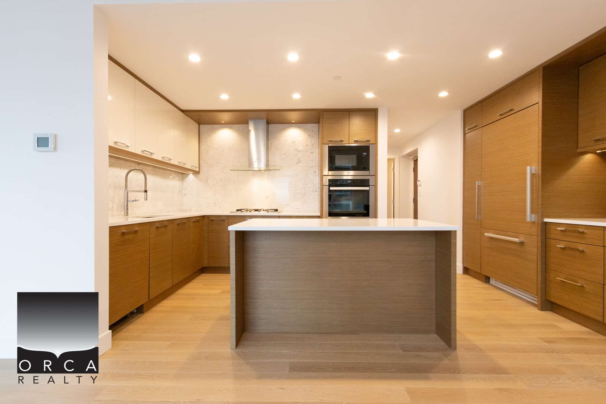 Spacious kitchen featuring sleek wooden cabinetry, stainless steel appliances, and a central island, perfect for contemporary living in Vancouver.