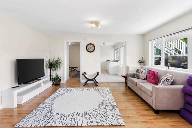 Bright and spacious living room in a West Vancouver home with large windows, contemporary furniture, and hardwood floors, perfect for family gatherings and relaxation.