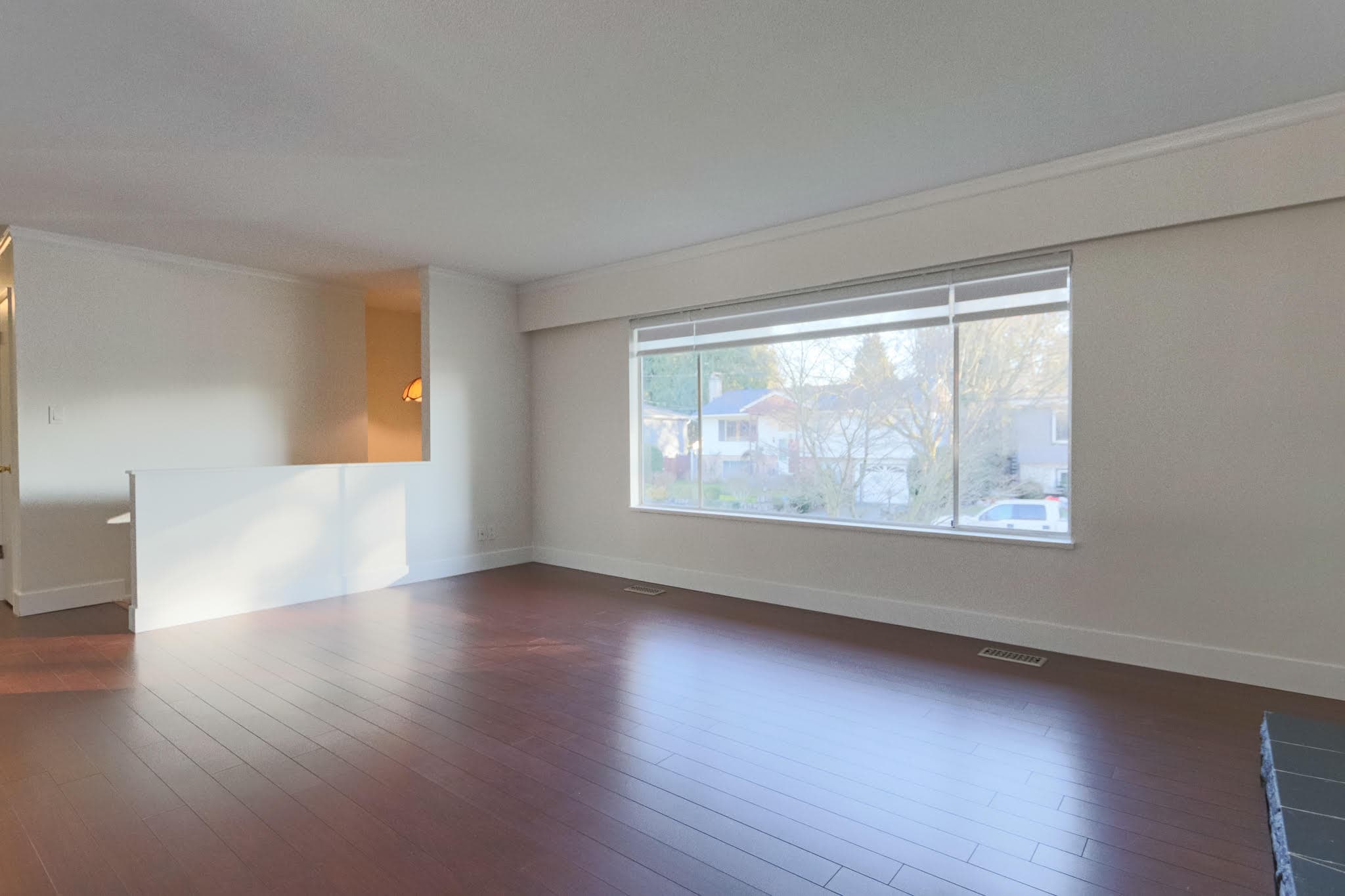 Bright and spacious living room with large window views in Delta property.