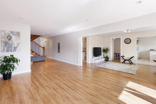 Bright and open living room with hardwood floors and modern decor in West Vancouver. Perfect for family gatherings and entertaining guests.