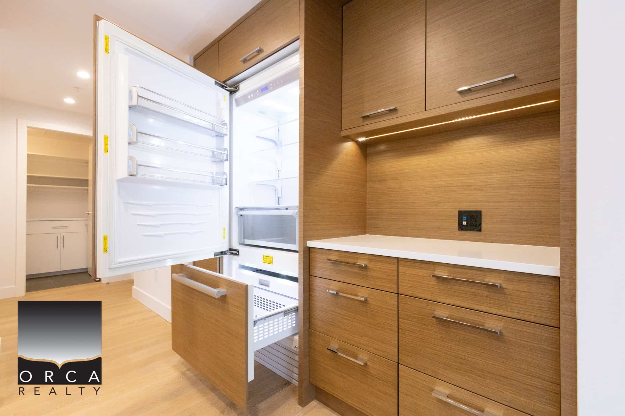 Spacious kitchen featuring a built-in refrigerator, sleek wooden cabinets, and ample storage space, perfect for contemporary Vancouver homes.