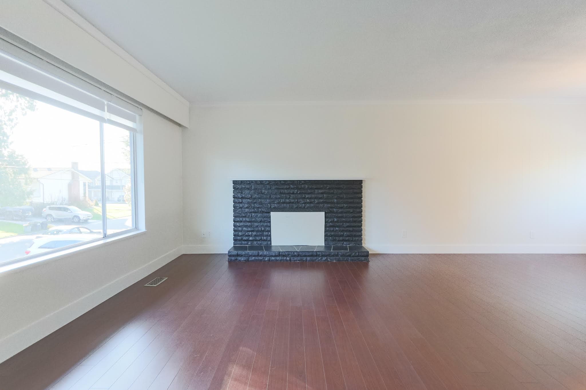 Bright living room featuring a large window and a modern black brick fireplace, perfect for relaxing and entertaining in Delta.