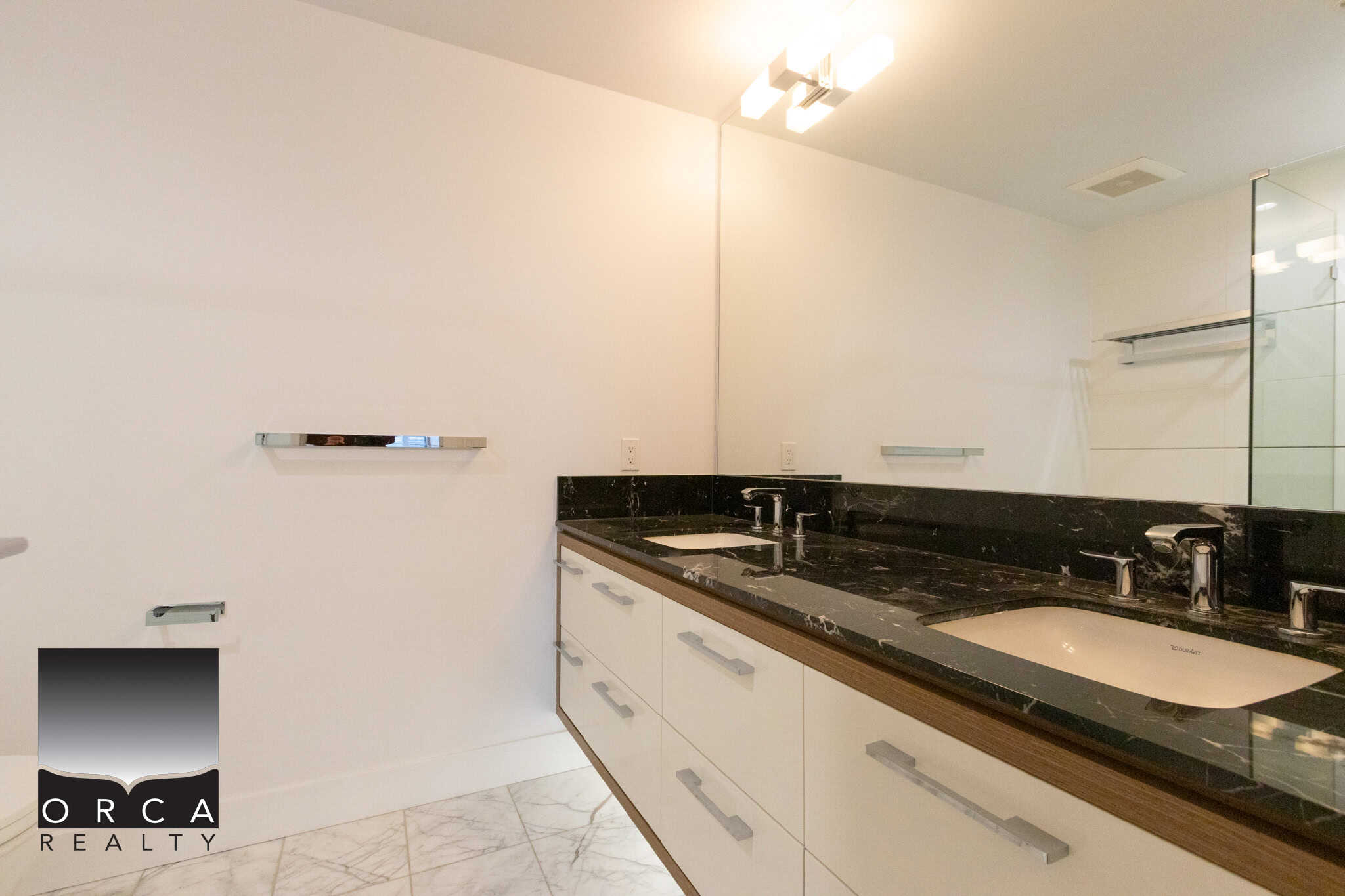 Spacious bathroom featuring dual sinks, black granite countertops, and contemporary fixtures in a Vancouver home at 1106-4360 Beresford Street.