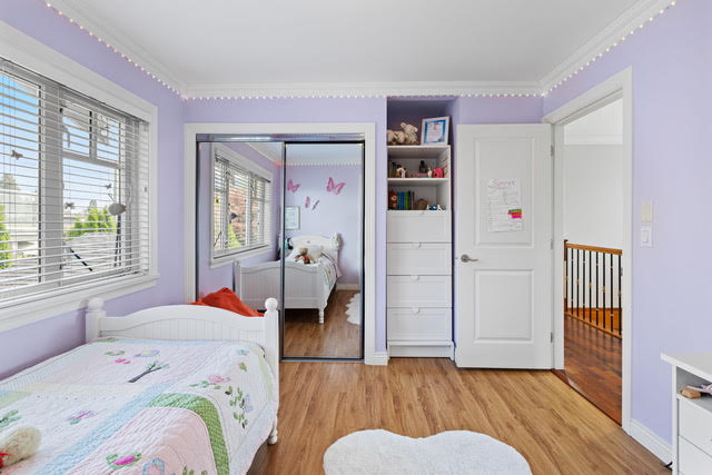 Bright kids' bedroom with lavender walls, white furniture, and large windows in West Vancouver. Perfect space for children with natural light and playful decor.