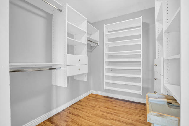 In closet with custom white shelving and ample storage space in West Vancouver home. Perfect for organizing clothing and accessories.