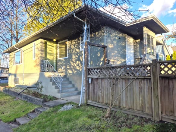 Spacious Vancouver residence at 5318 Bruce Street featuring a welcoming front porch, lush yard, and modern design, ideal for families seeking comfort and convenience in a prime location.