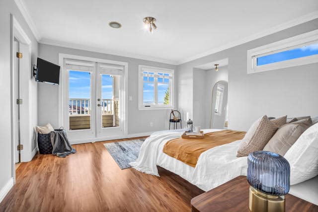 Bright West Vancouver bedroom with large windows, ocean views, and stylish furnishings.