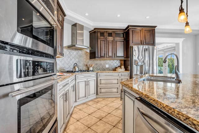 Spacious kitchen featuring granite countertops, modern appliances, and custom wood cabinets in a luxurious West Vancouver home.